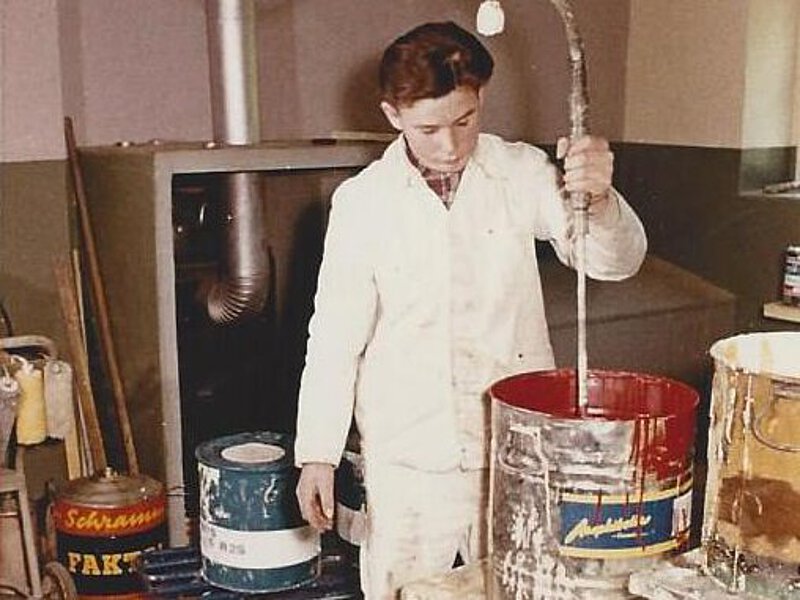 Lehrling beim Farbenanrühren