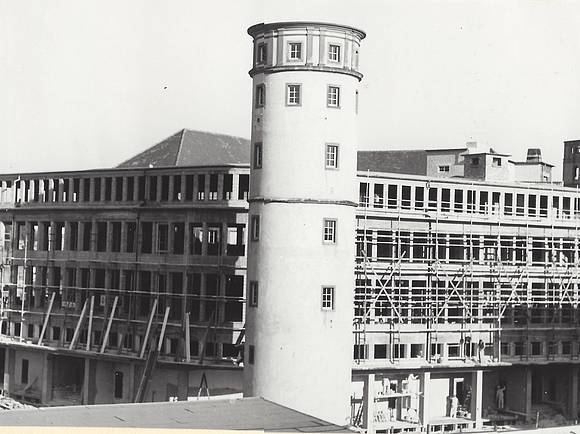 Der Neubau des Kaufhauses Henschel & Ropertz mit Weißem Turm im Vordergrund.