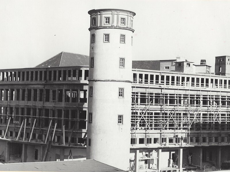 Der Neubau des Kaufhauses Henschel & Ropertz mit Weißem Turm im Vordergrund.